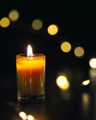 Burning candle on black background with bokeh. Memorial Day. High quality photo